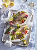 Baked trout en papillote with vegetables and herbs