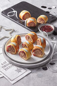 Minced meat rolls wrapped in puff pastry with cranberries and sage