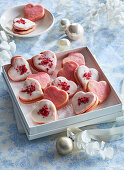 Filled, heart-shaped biscuits with raspberry icing