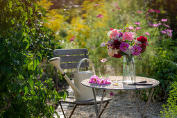 Garden seating area with bouquet of dahlias (Dahlia), roses (Rosa), autumn anemones (Anemone Hupehensis) and wild carrot