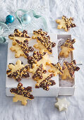 Snowflake-shaped biscuits with chocolate icing and nuts