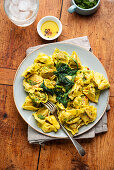 Wild garlic tortellini with spinach leaves and pesto