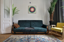 Living room with dark green sofa and oriental carpet