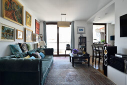 Living room with dark green velvet sofa and art on the wall