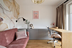 Modern study with desk, pink velvet sofa and floral wallpaper