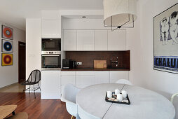 Light-colored kitchen with dining area in white