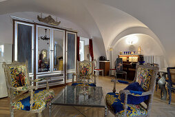 Living room with arched ceiling, baroque armchairs and mirror cabinet