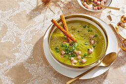 Pea soup with bacon cubes and crispy breadsticks