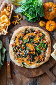 Pumpkin and savoy cabbage pizza with ham and mushrooms