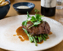 Fillet steak on green beans with pepper sauce