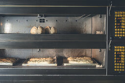 Frische Brotlaibe aus Sauerteig im Gärprozess im Ofen