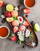 Fruity mochi with strawberries and citrus fruits on a wooden board