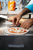 Pizza chef topping Margherita pizza