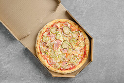 Pizza with ham and pickled gherkins