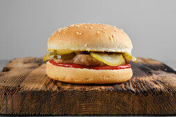 Hamburger im Sesambrötchen mit Essiggurke und Ketchup