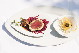 Saddle of venison wrapped in pastry with herbs and garnish