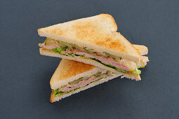 Club sandwich with ham and pickled cucumber