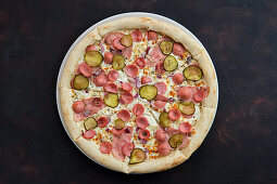 Pizza with Vienna sausage, ham, gherkins and onions