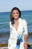 Woman in white blouse with blue flower pattern on the beach