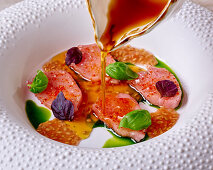 Bonito sashimi in tomato consommé with basil oil