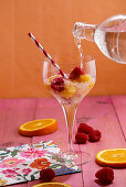 Water with raspberry and orange ice cubes