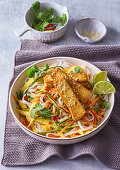 Asian noodle salad with mango strips, fried tofu and coriander