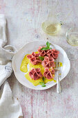 Rose ravioli with eggplant and goat's cheese filling on saffron sauce