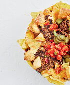 Cheeseburger nachos with tomatoes and pickles