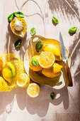 Whole and sliced lemons with basil leaves