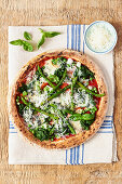 Gartenpizza mit grünen Gemüsesorten und Parmesan