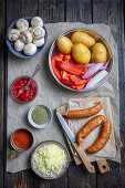 Ingredients for potato and sausage casserole with vegetables