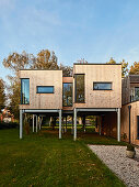 Modern wooden house on stilts in a spacious garden