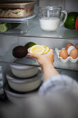 Woman puts lemon slices in the fridge