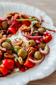 Summer salad with tomatoes, olives and pecans