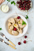 Sauerkirsch-Pierogi mit frischen Kirschen und geschmolzener Butter