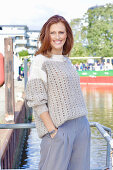 Rothaarige Frau in braun-beigem Strickpullover mit Lochmuster