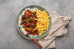 Peruvian Lomo Saltado" with beef, chips, rice and vegetables"