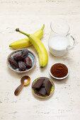 Ingredients for banana date chocolate ice cream with cocoa powder and milk