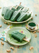 Spirulina ice cream on a stick with cashew nuts