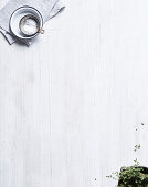 Coarse sea salt and oregano on a white glazed wooden base