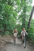 Zwei junge Frauen auf Fahrrad, Berlin, Germany