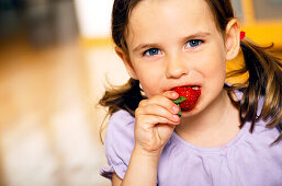 Mädchen isst Erdbeere