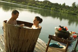 Couple in bathtub at mtwapa creek, people in water