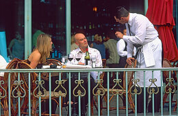 A couple and a waiter at the Brasserie of the Paris Paris Hotel and Casino, Las Vegas, Nevada, America