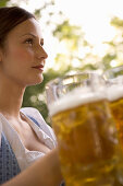 Junge Frau im Biergarten mit Bierkrug, Starnberger See, Bayern, Deutschland