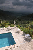 Pool of the Hotel Posada del Marques with view at scenesy and thunder clouds, Majorca, Spain