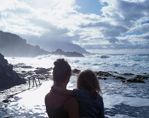 Mutter hält Tochter auf dem Arm, Seewasserschwimmbad, Punta Grande, El Hierro, Kanarische Inseln