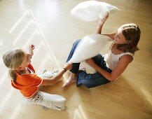 Two girls having a pillow-fight, people