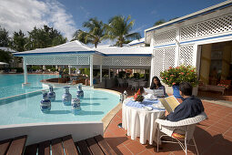 Hotelpool, Couple, Table, Reading, Couple dining near the pool, Hotel La Cocoteraie, Le Meridien, Saint-Francois, Grande Terre, Guadeloupe, Caribbean Sea, America