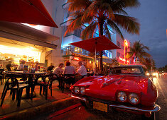 Classic car parking beside a sidewalk cafe, Ocean Drive, South Beach, Miami Florida, USA